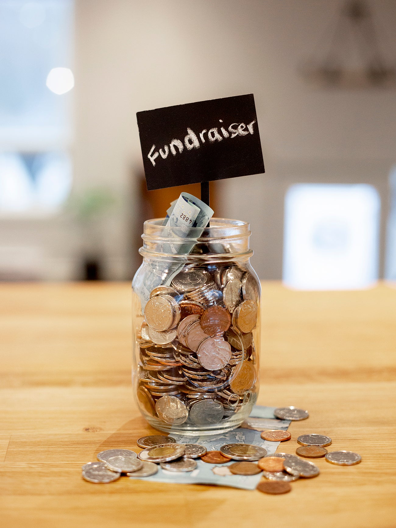 A small jug with lots of coins as saving for a fundraising purpose